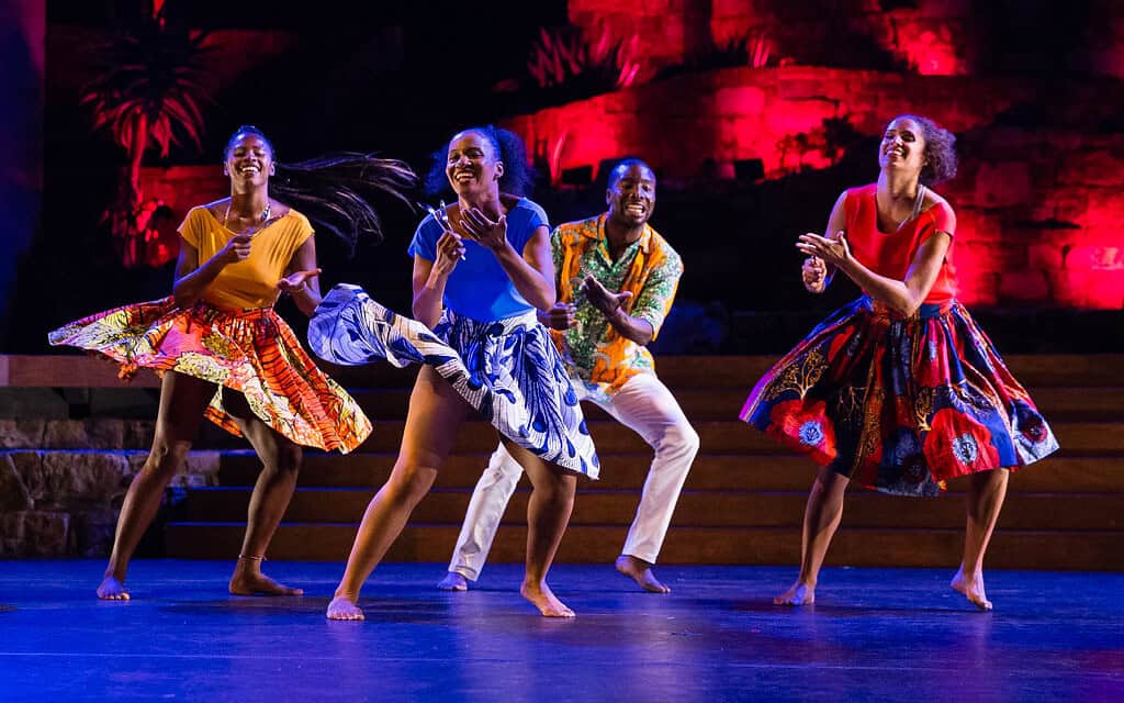 Image of 4 Viver Brasil dancers on stage with dramatic lighting