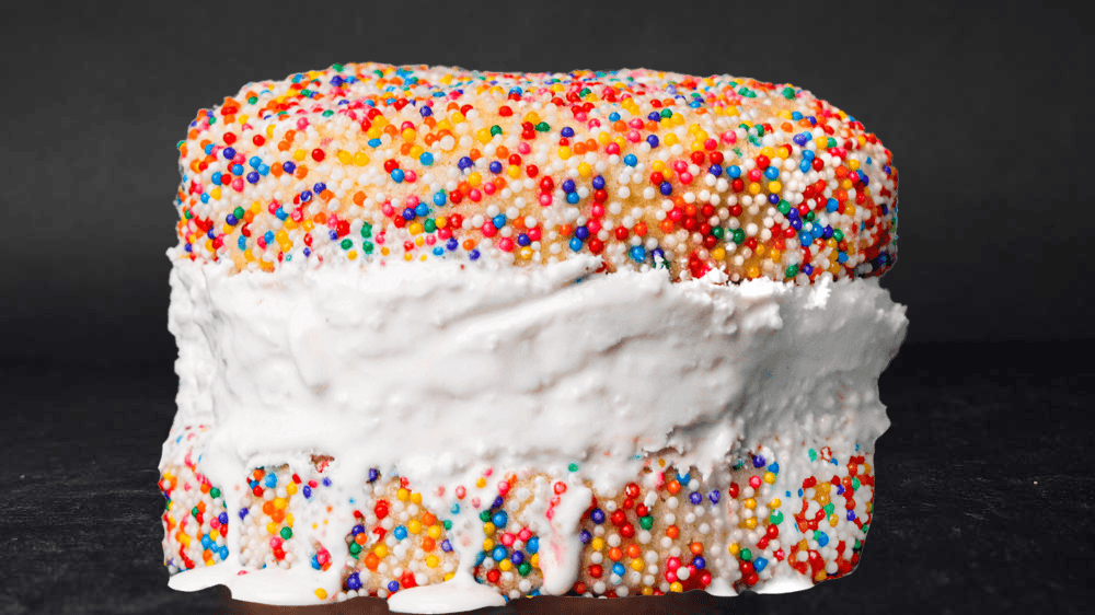 Thick cookies with sprinkles with thick slab of creamy vanilla melting  ice cream 