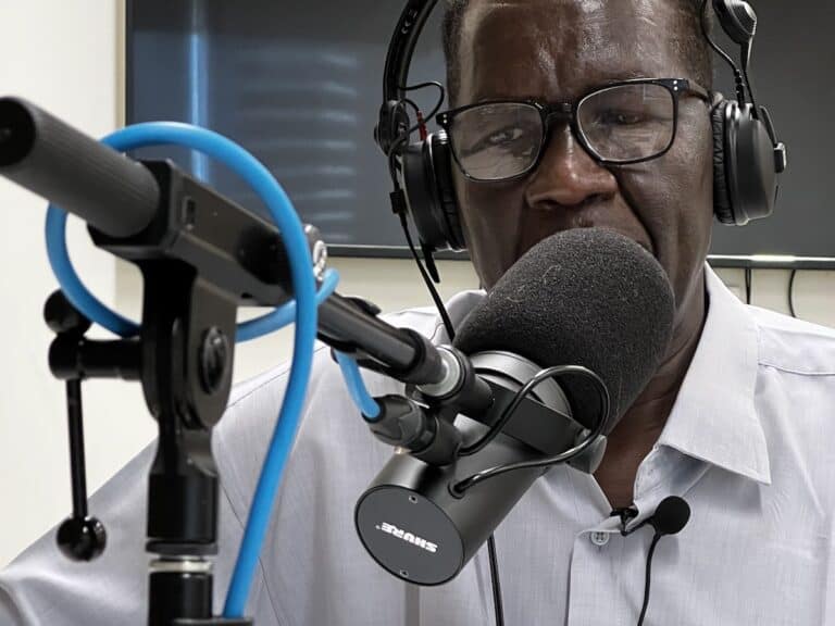 Man wearing headphones speaking into a microphone