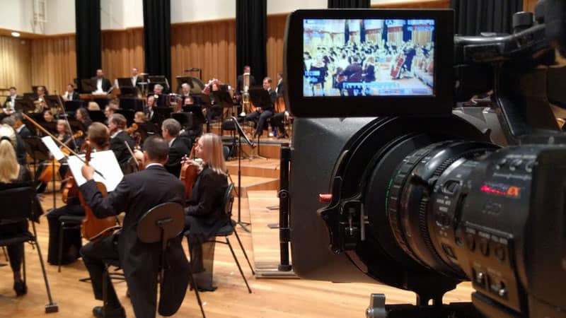 Video production view from camera looking towards Queensland Symphony Orchestra players during a video recording session.