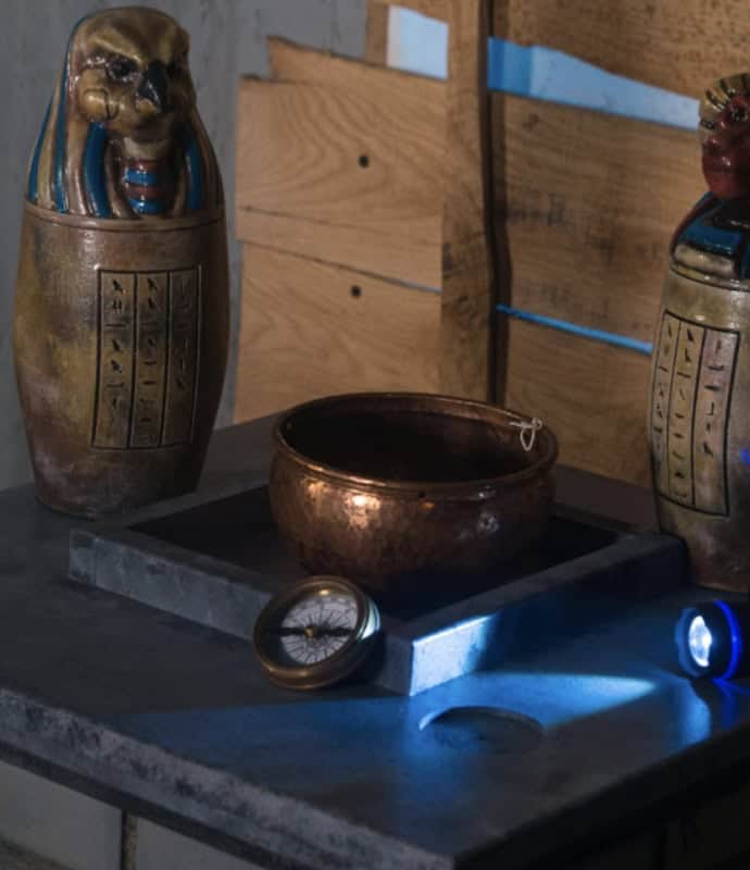 A table with two egyptian vases and a blue light.