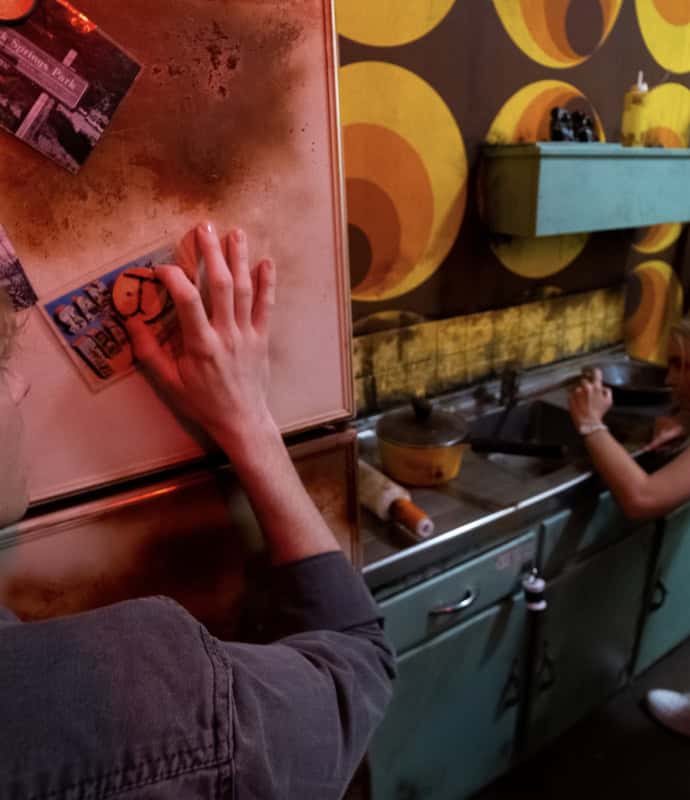 A man and woman in a kitchen.