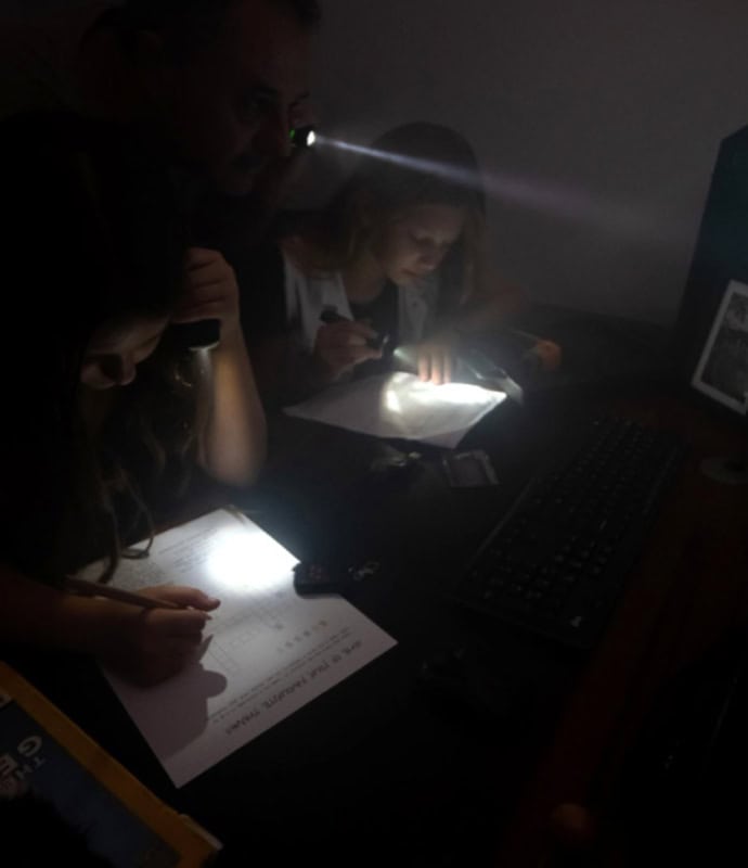 A group of people working on a computer in the dark.