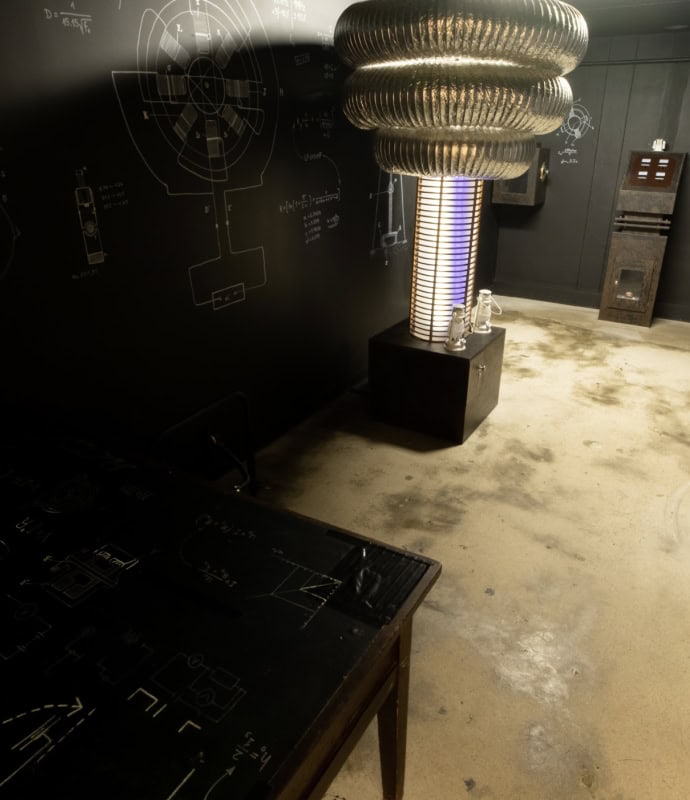 A room with a table and a lamp on the wall.