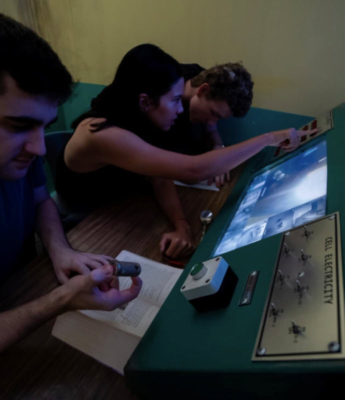 Three people looking at a computer screen in a museum.