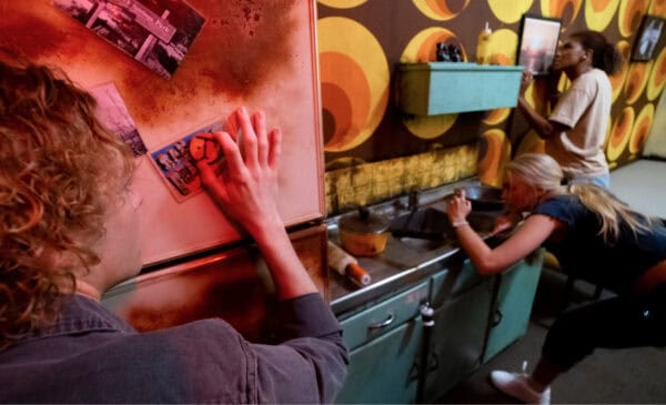 Two people are looking at a refrigerator in a kitchen.
