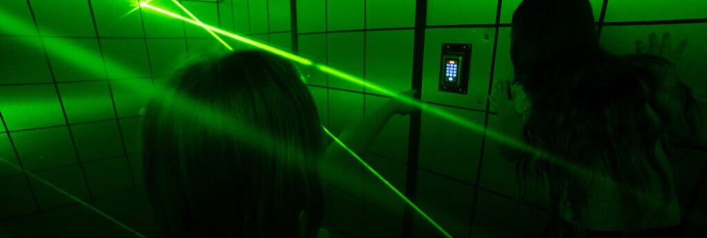 A woman is standing in front of a green laser.