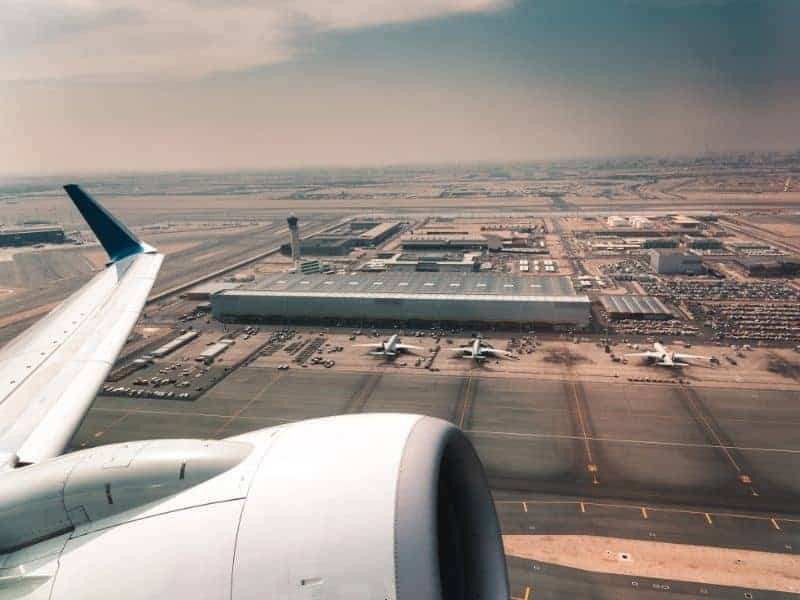 Aerial view of Hamad International Airport in Doha, Qatar, shot from an airplane, with the plane's engine in view.