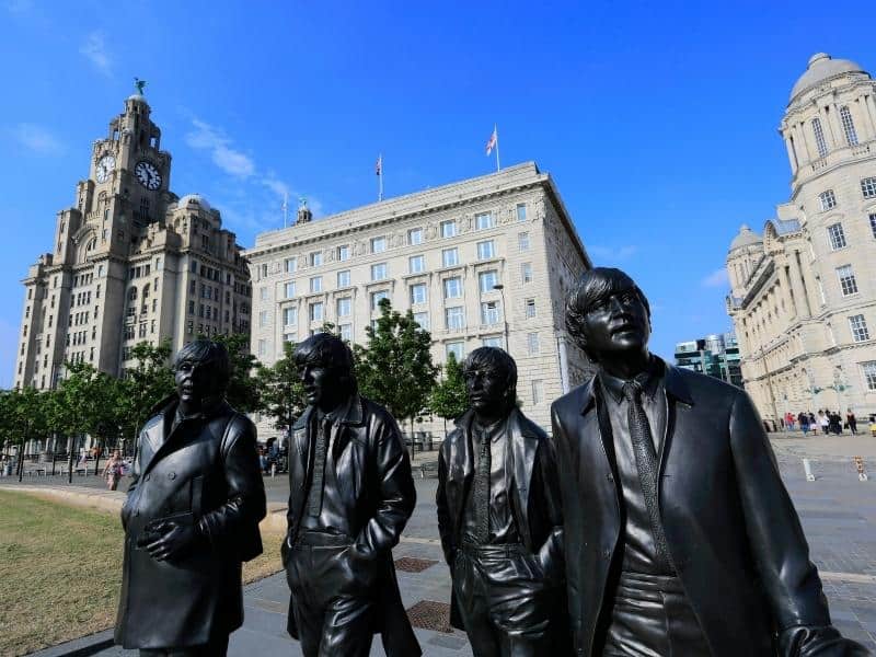 Statue of the band The Beatles with some Liverpool architecture in the background