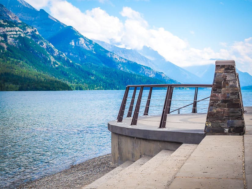 Monument and stone staircase down to a lake in Waterton Lake National Park with mountains in background