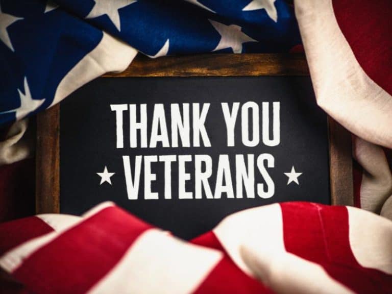 Thank you veterans message on blackboard with American flags.