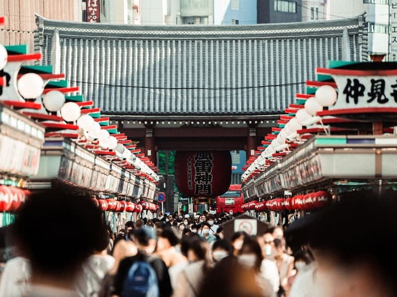A bustling crowd in Nakamise Street, leading to Senso-ji Temple in Tokyo, Japan.