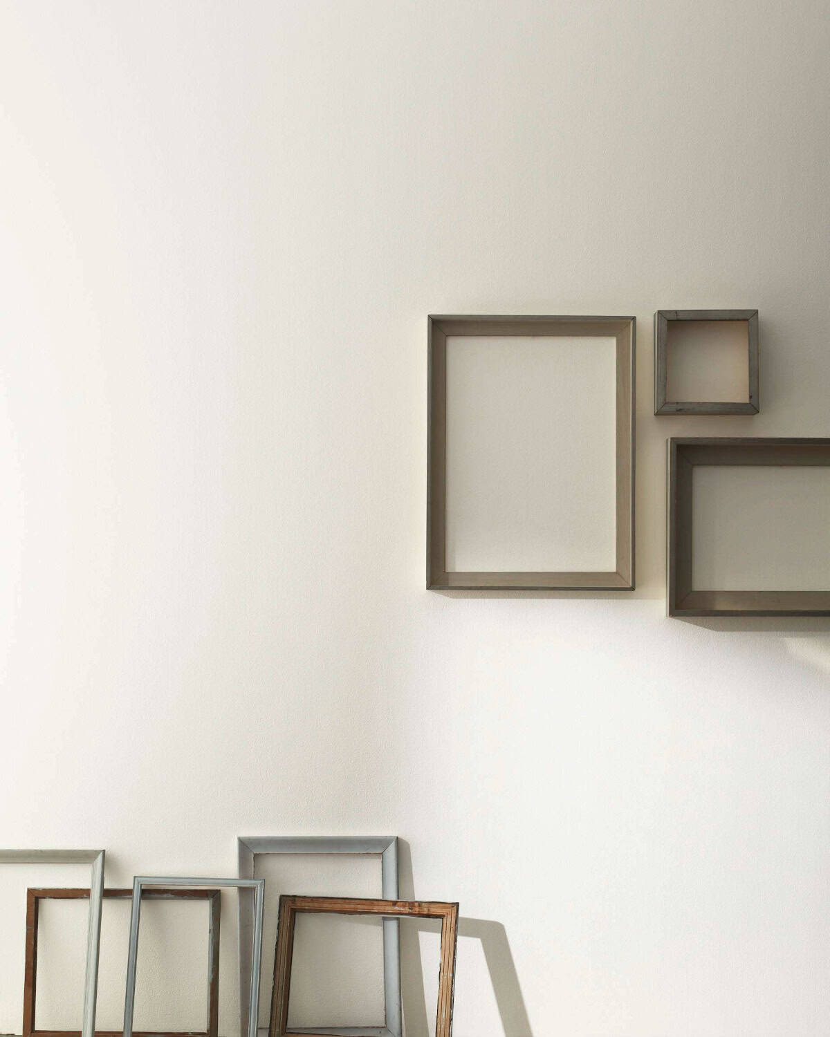 wall painted with benjamin moore paint in steam colour with wooden frames hanging from it.