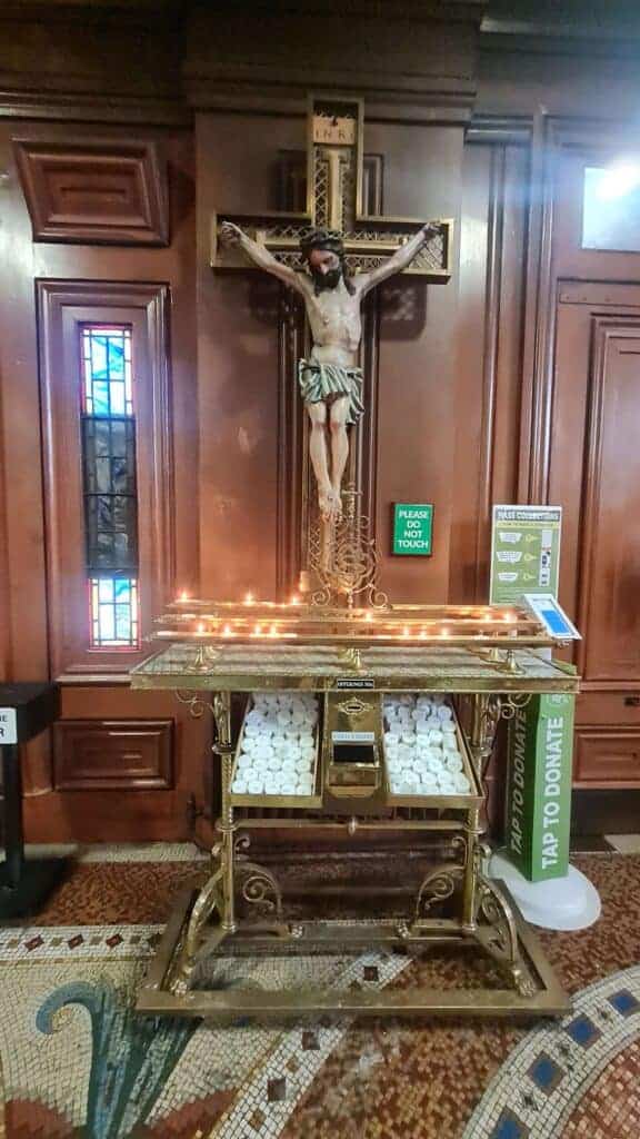 Cristo crucificado en la entrada de la catedral y velas para dejar encendida.