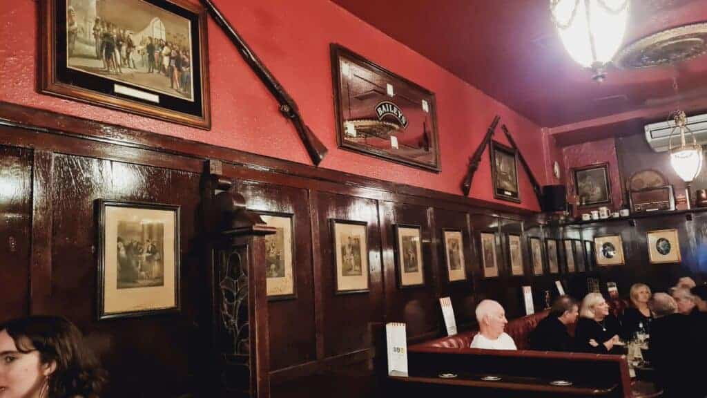 Pared del pub con armas viejas y cuadraos