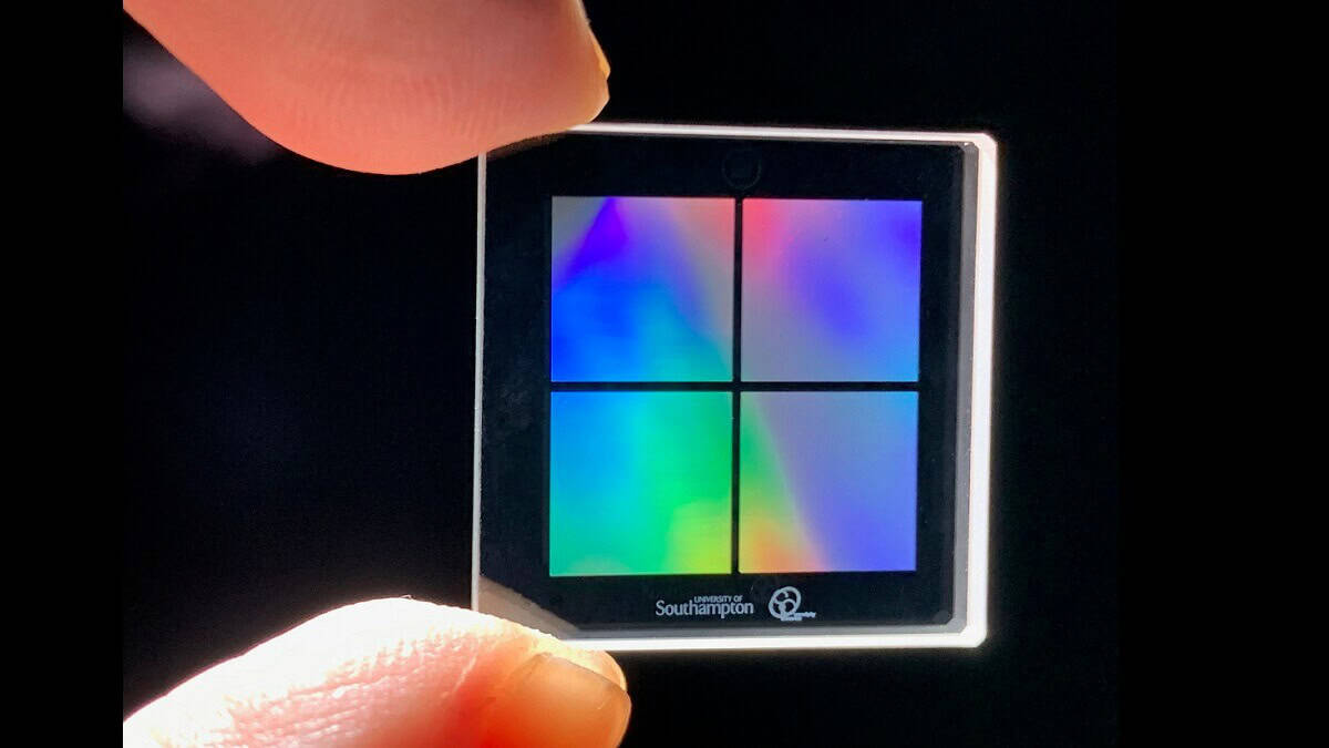 photo of fingers holding data stroage glass chip