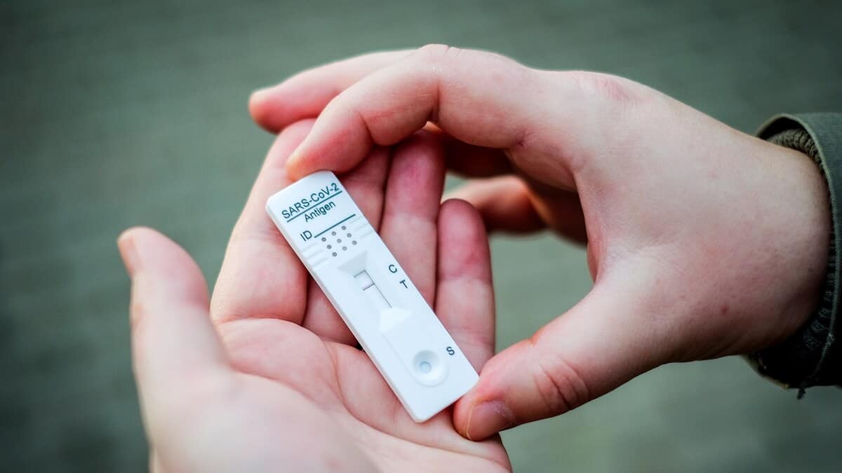 Two hands hold a rapid antigen test for COVID-19