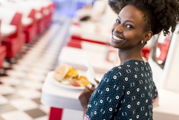 Black woman smiling as she learns to eat slowly