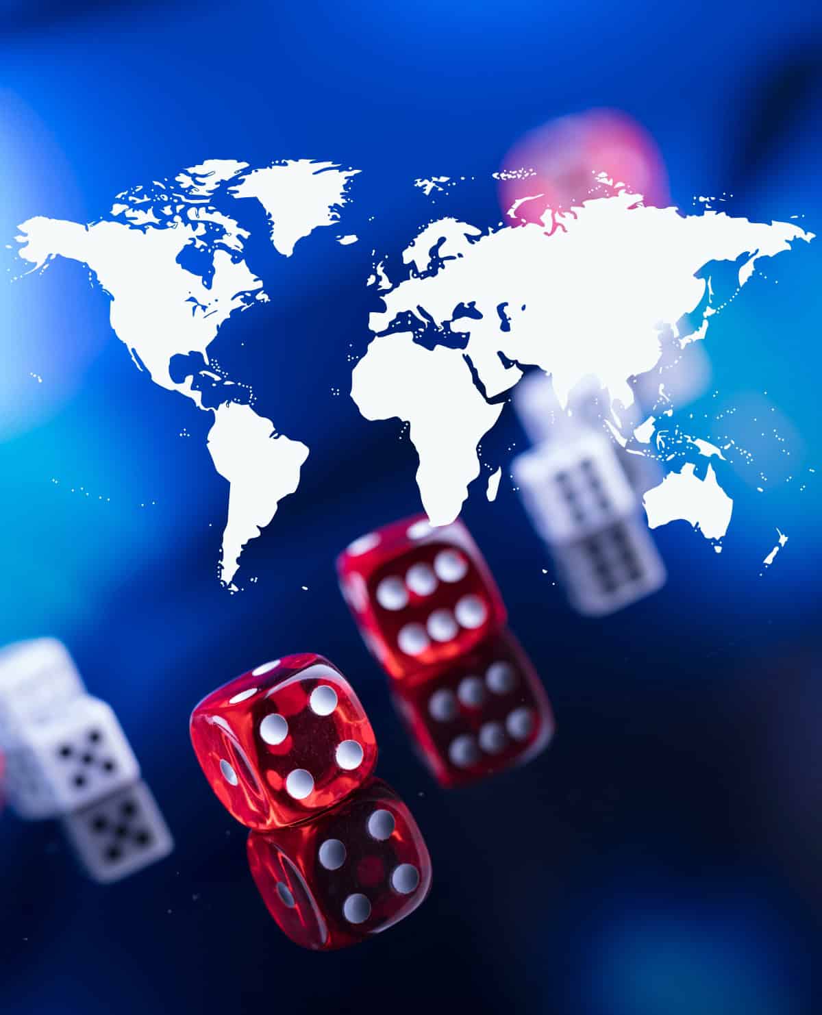 World map in white overlaying a blue background with transparent red and white dice in the foreground, representing the global spread and regulatory complexity of online gambling.