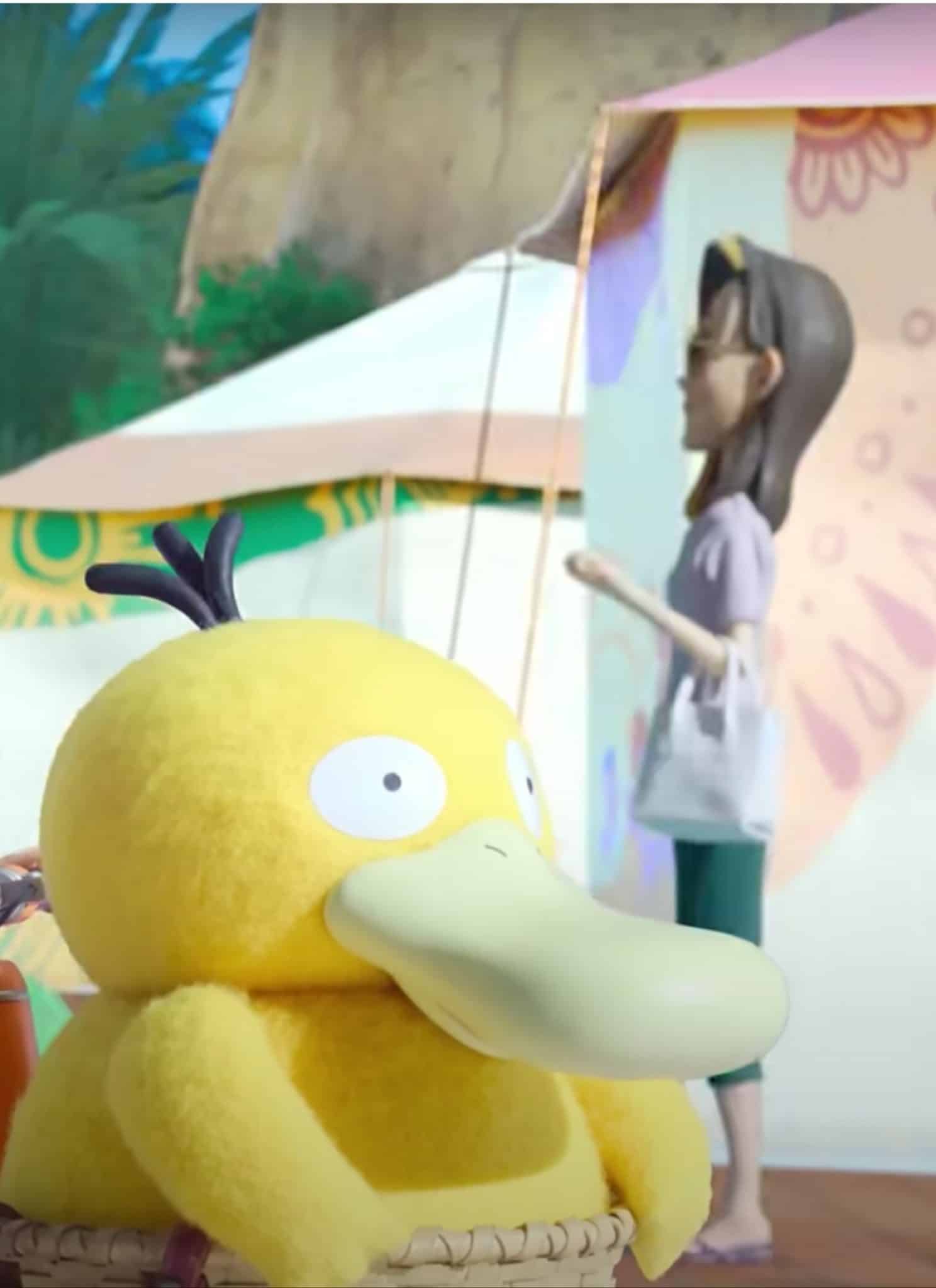 An animated woman with red hair stands behind a Psyduck Pokemon in foreground with tents in background.