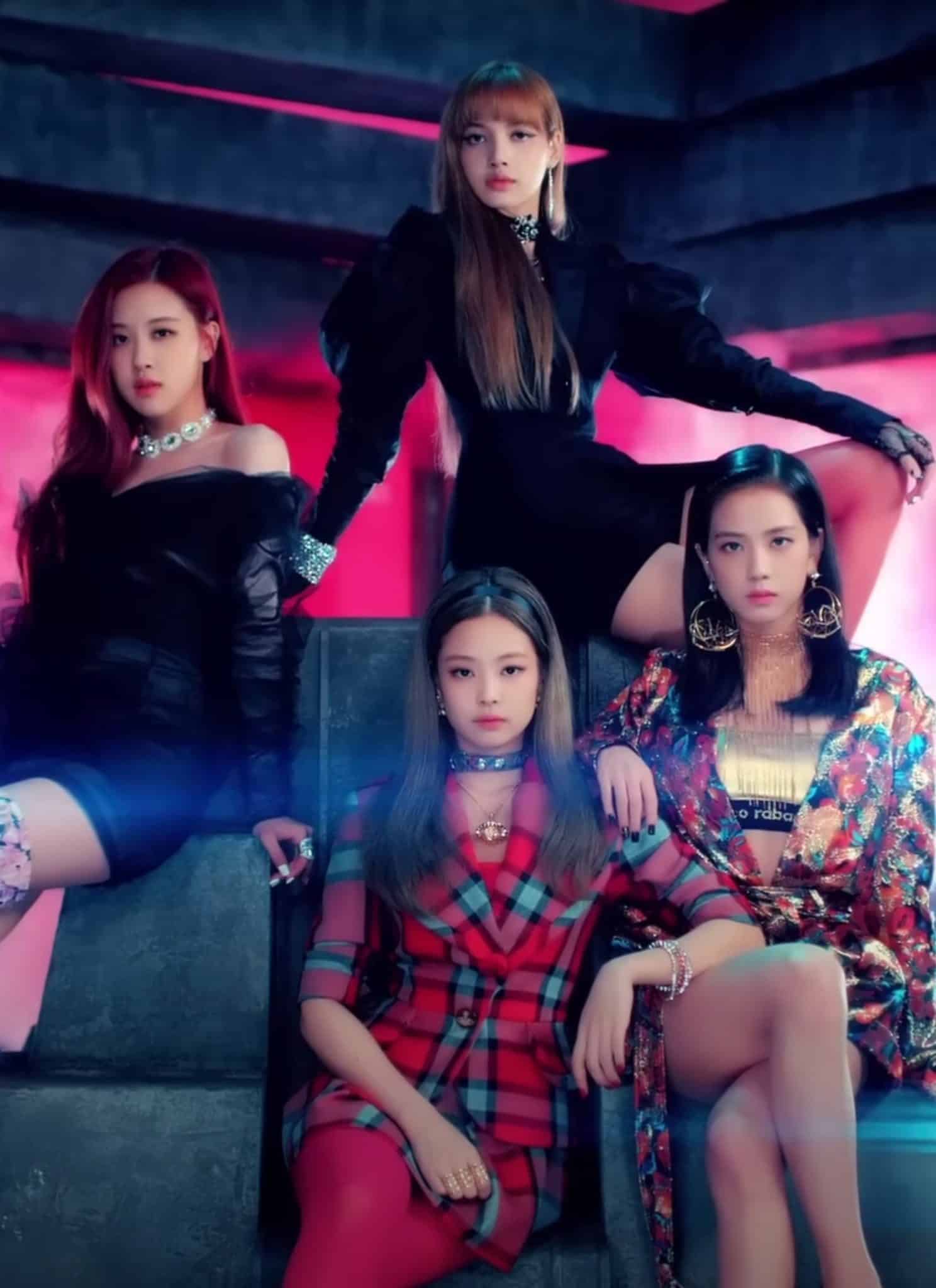 4 girls in BLACKPINK group sitting together on a throne.