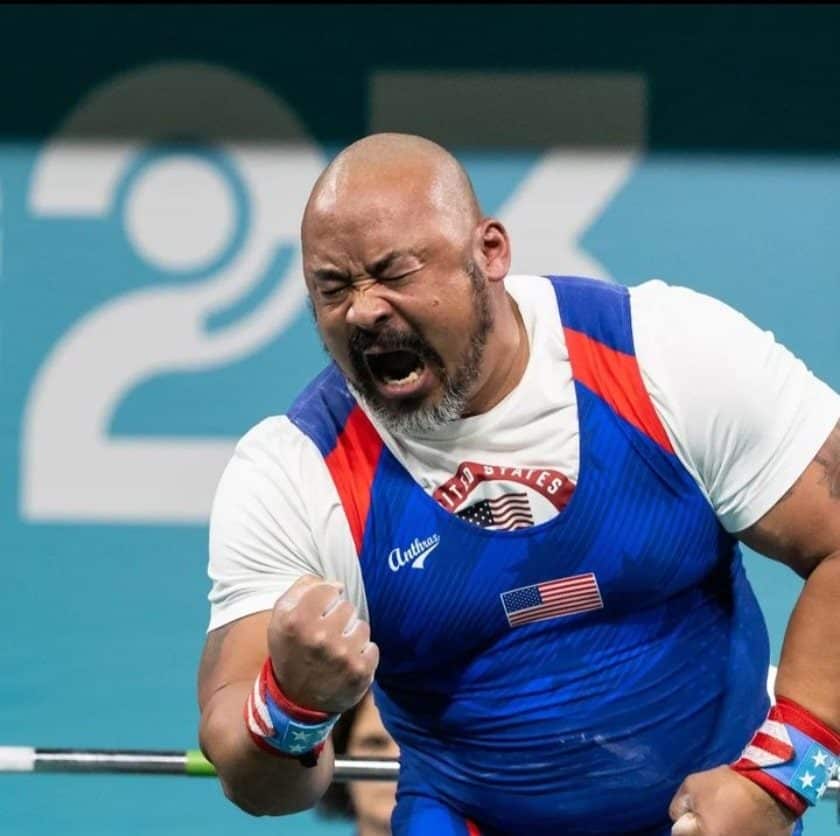Para powerlifter Bobby Body in blue and white top celebrates with his eyes closed and fist clenched at the 2023 Parapan American Games.