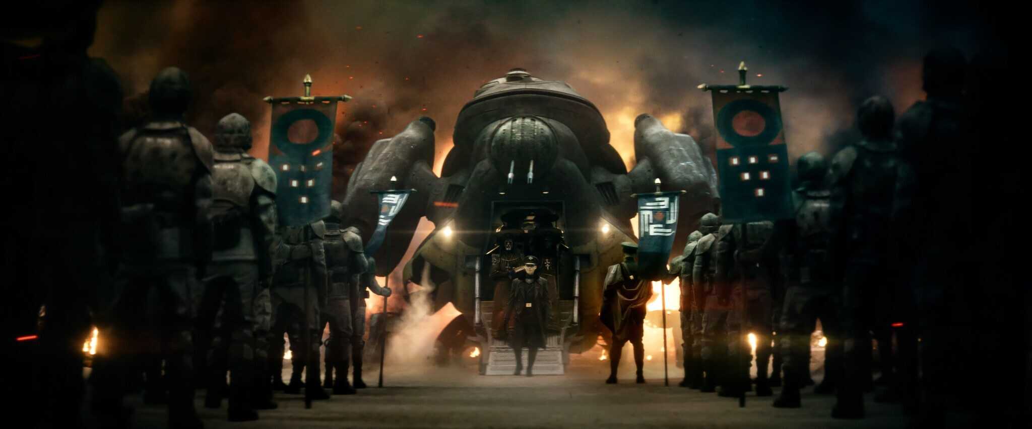 Actor Ed Skrein as Atticus Noble in "Rebel Moon — Part Two: The Scargiver," in military clothes, with soldiers lined up on either side of him.