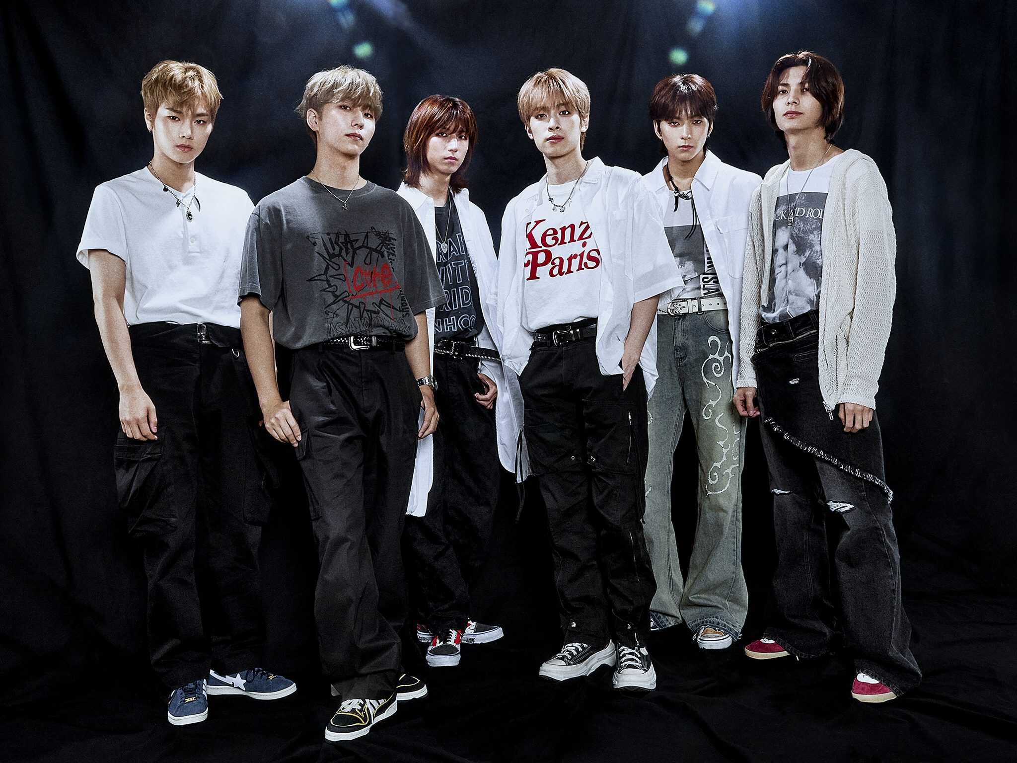 Members of the K-rock band Xdinary Heroes, against a dark background.