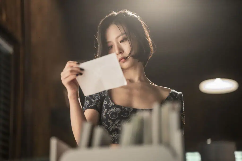 Still from the show "The Frog." A Korean woman reads a piece of paper.