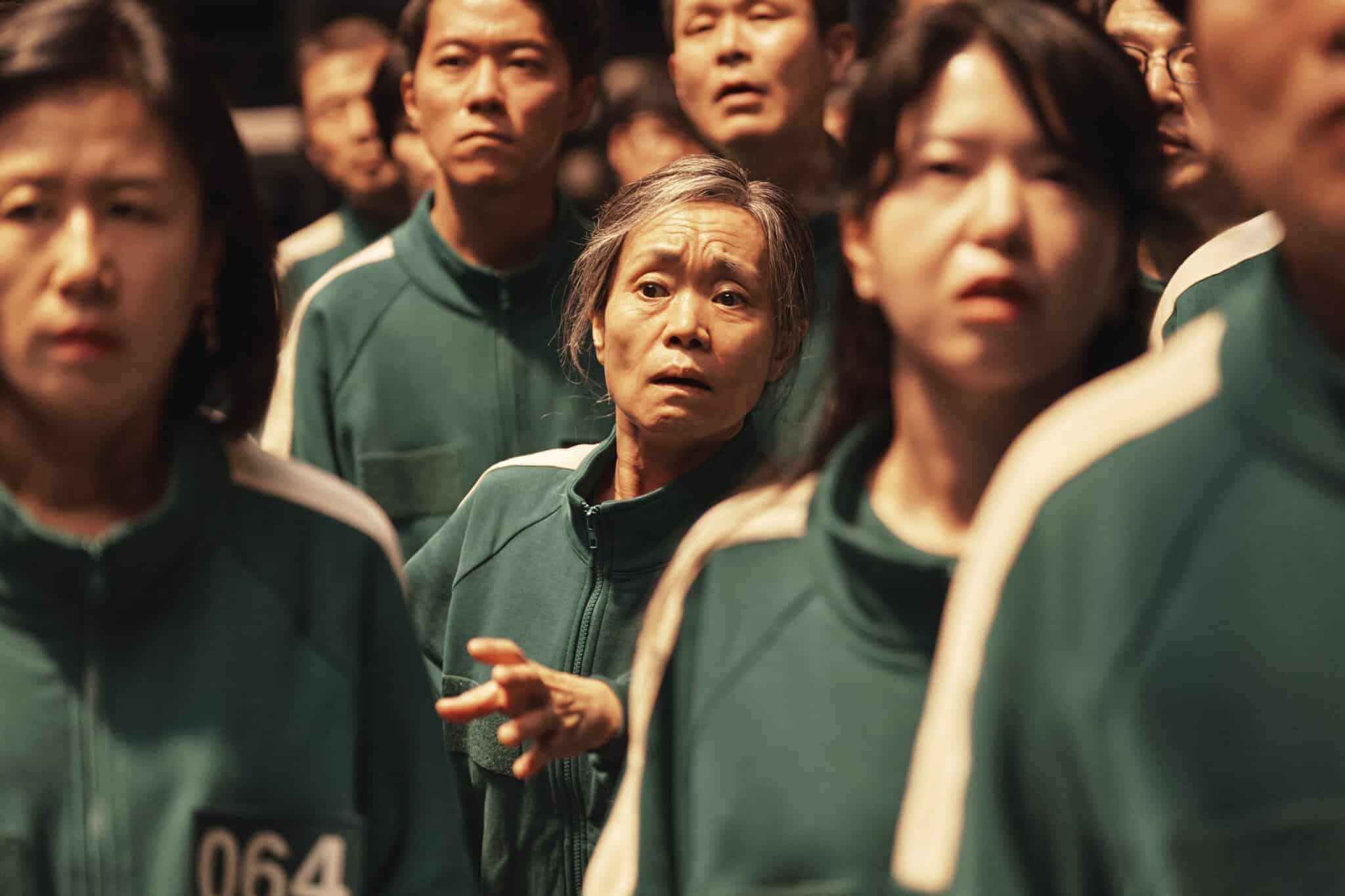 Kang Ae-sim as Player 149 standing among a crowd of other game participants.