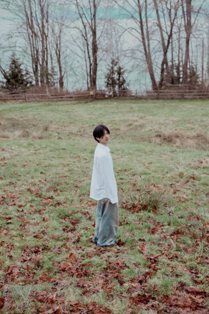 yung kai standing in a field.
