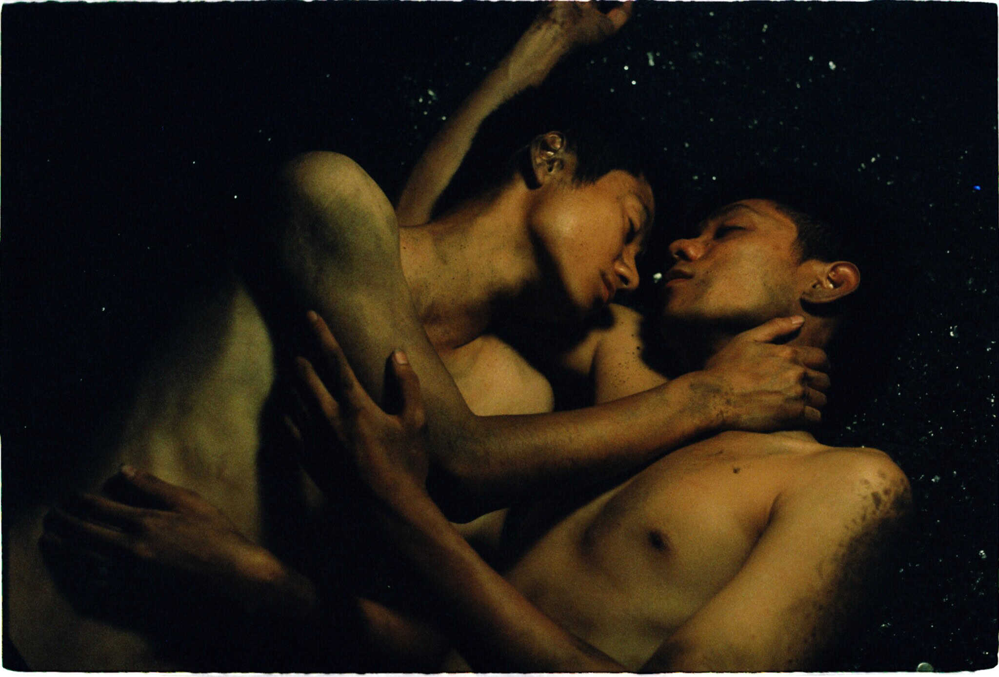 Still from "Viet and Nam"; two men embracing.