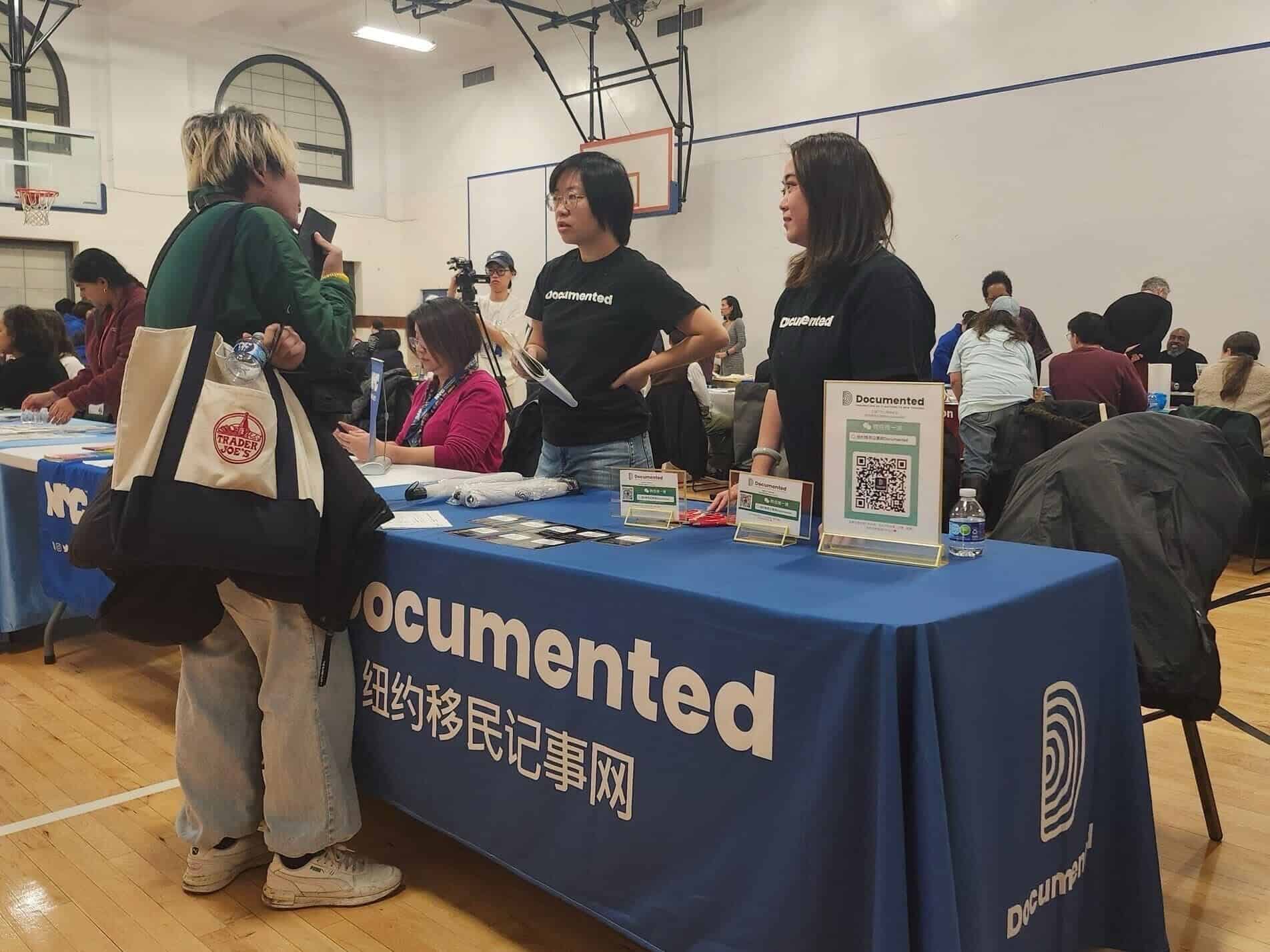 April Xu (middle) and her colleague Faye Qiu speaking with Chinese immigrants at the Non-Profit & Immigrant Resource Fair in Flushing, hosted by the Queens Borough President's Office