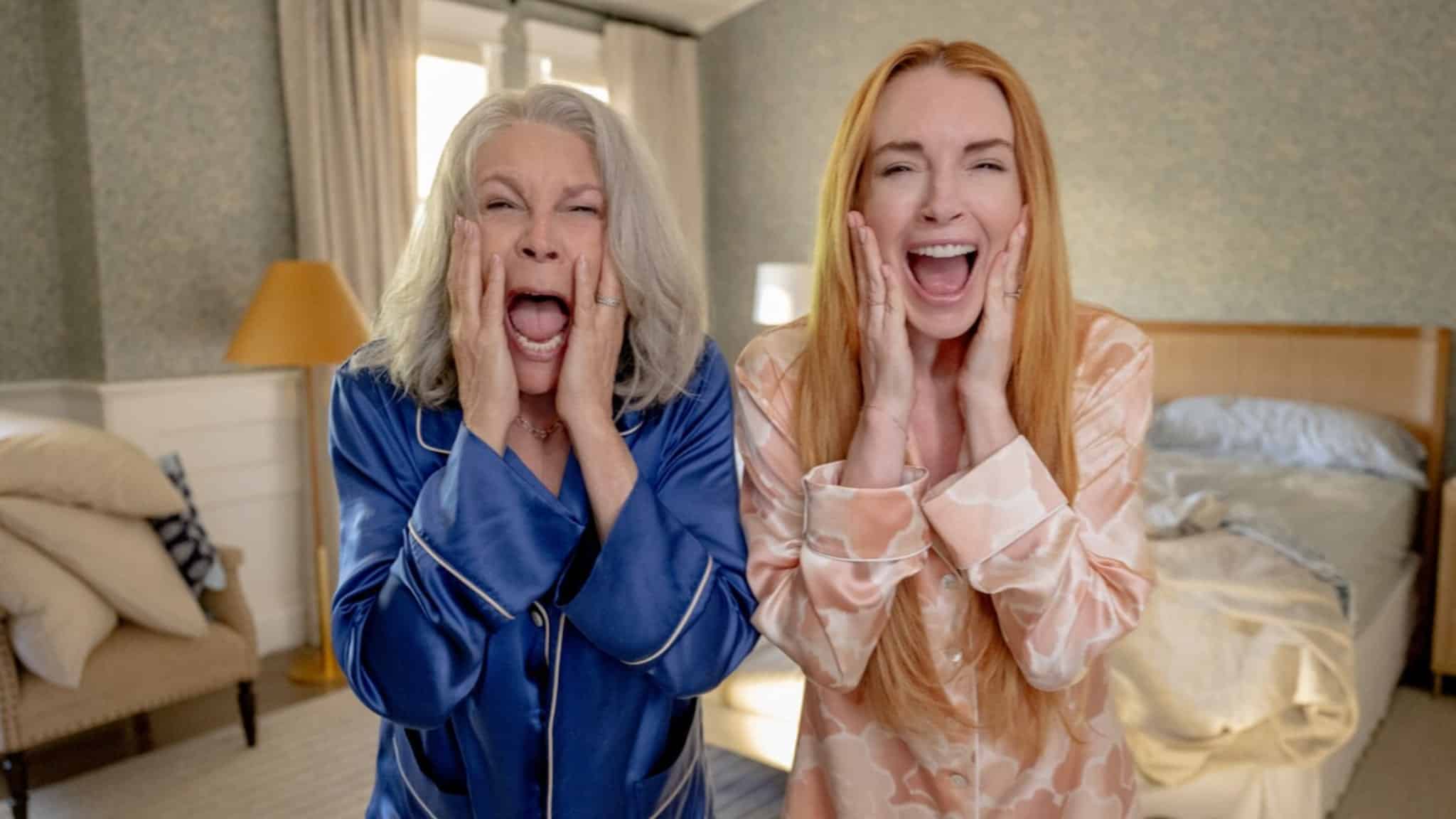 Jamie Lee Curtis in blue outfit and Lindsay Lohan in red screaming.