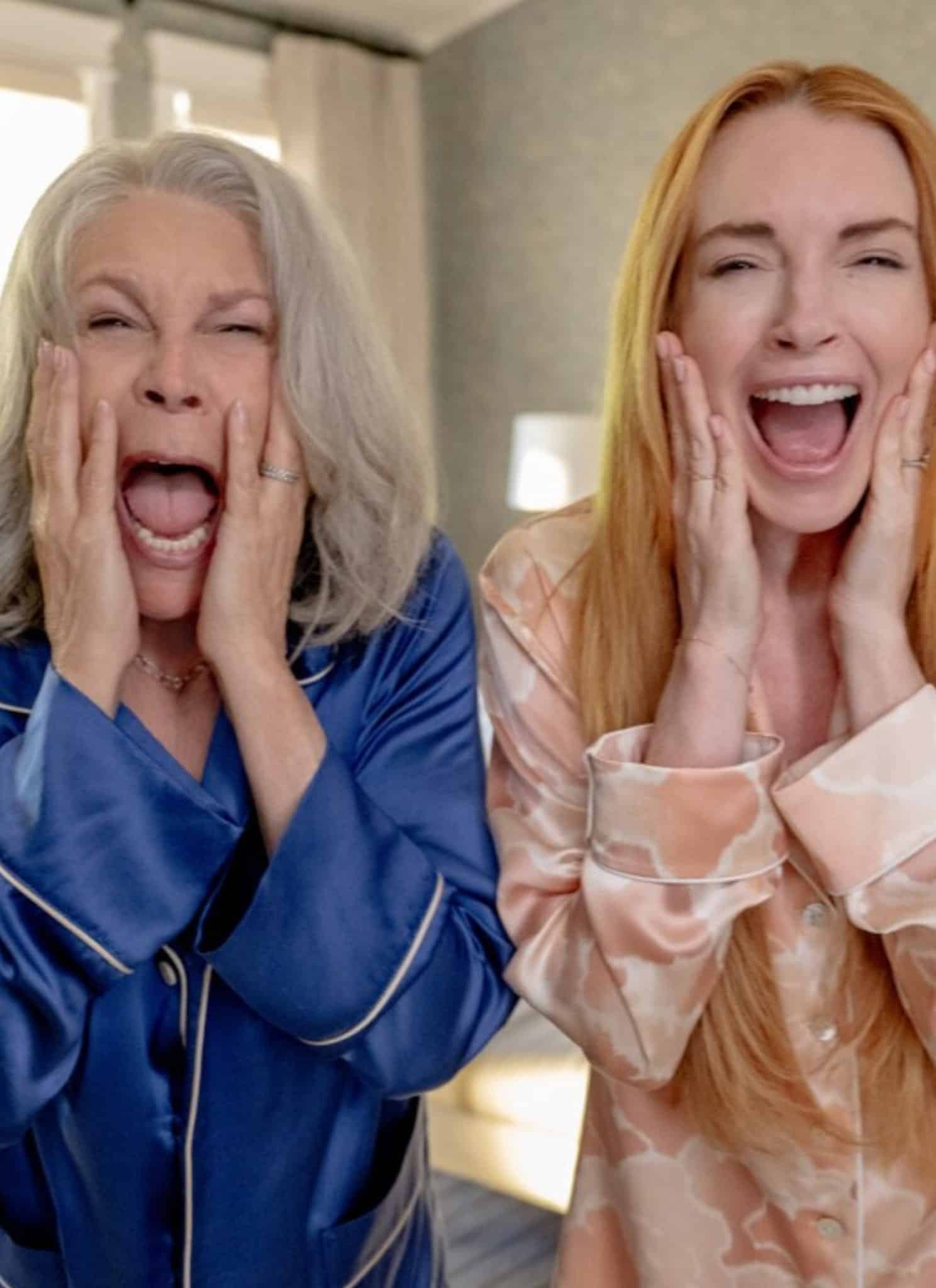 Jamie Lee Curtis in blue outfit and Lindsay Lohan in red screaming.