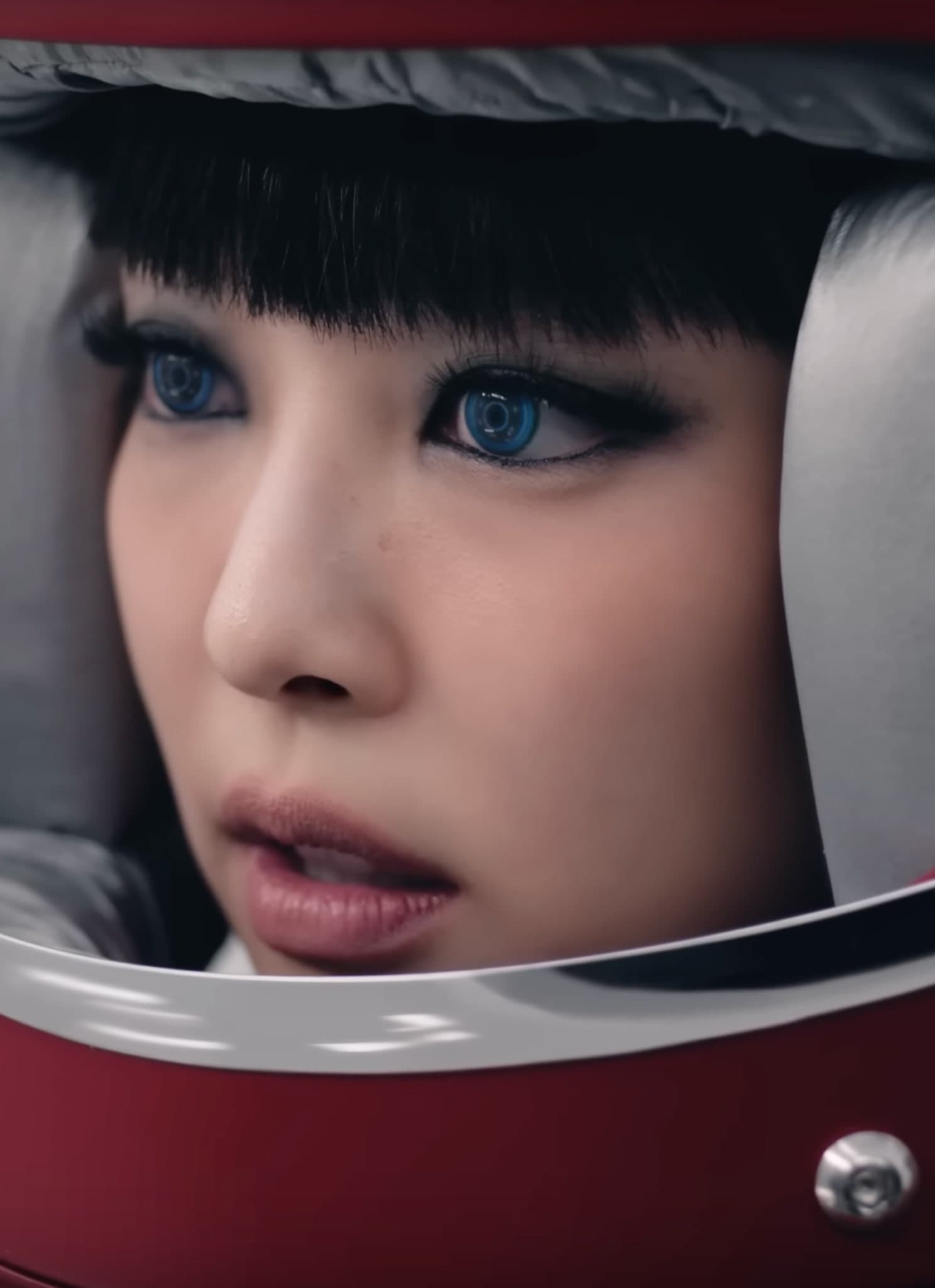 Jennie Kim in red astronaut helmet with blue contacts.