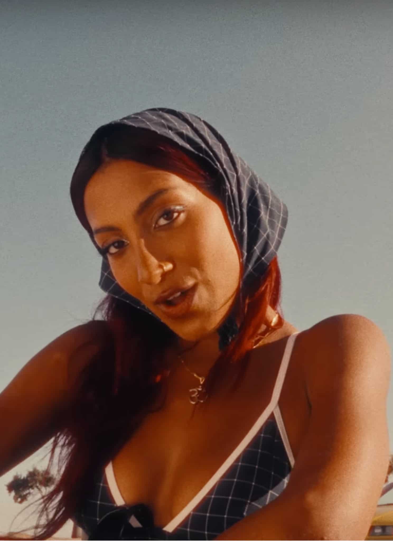 Lara Raj squatting on beach parking lot.