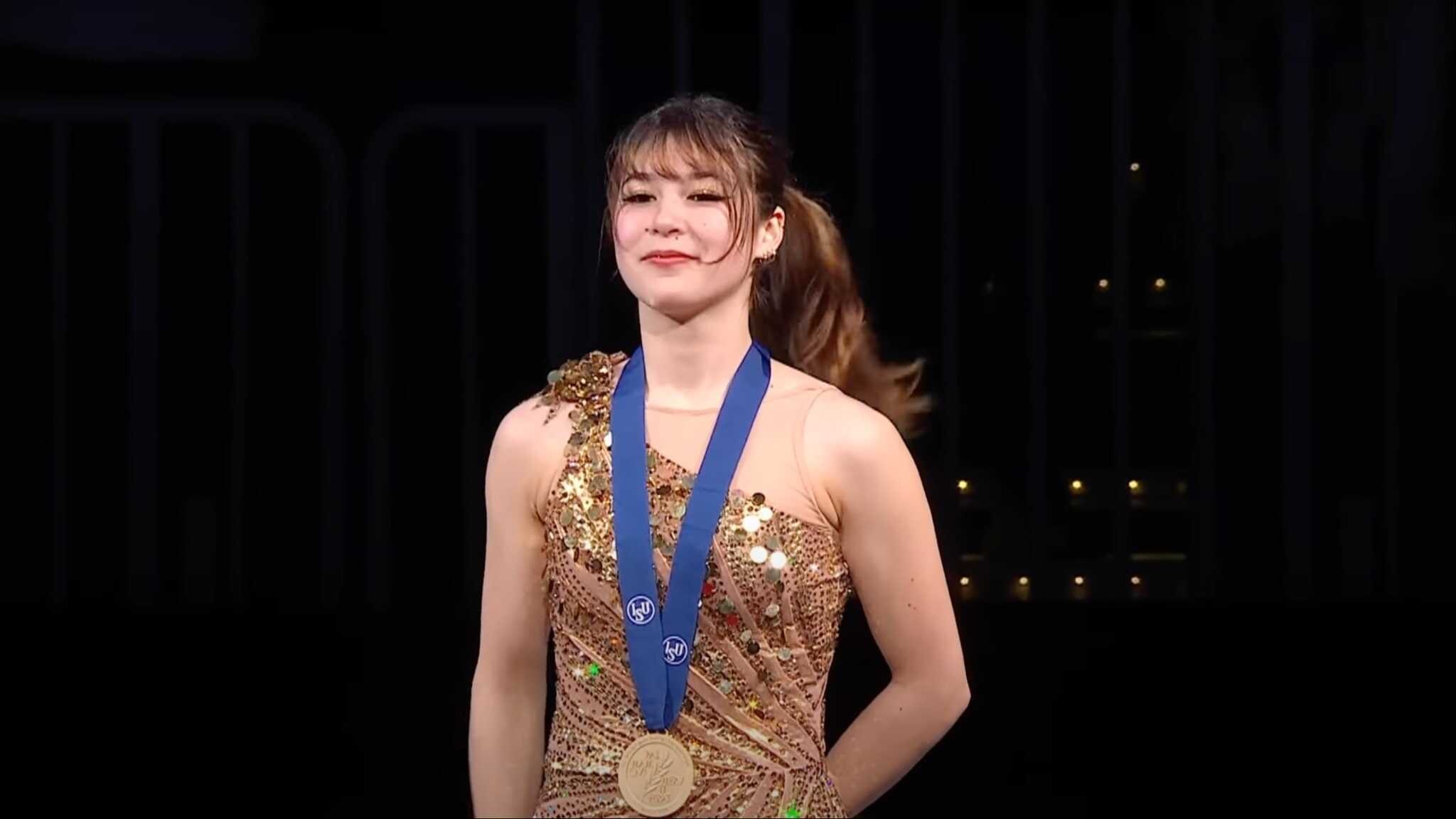 Alysa Liu in gold dress with gold medal.