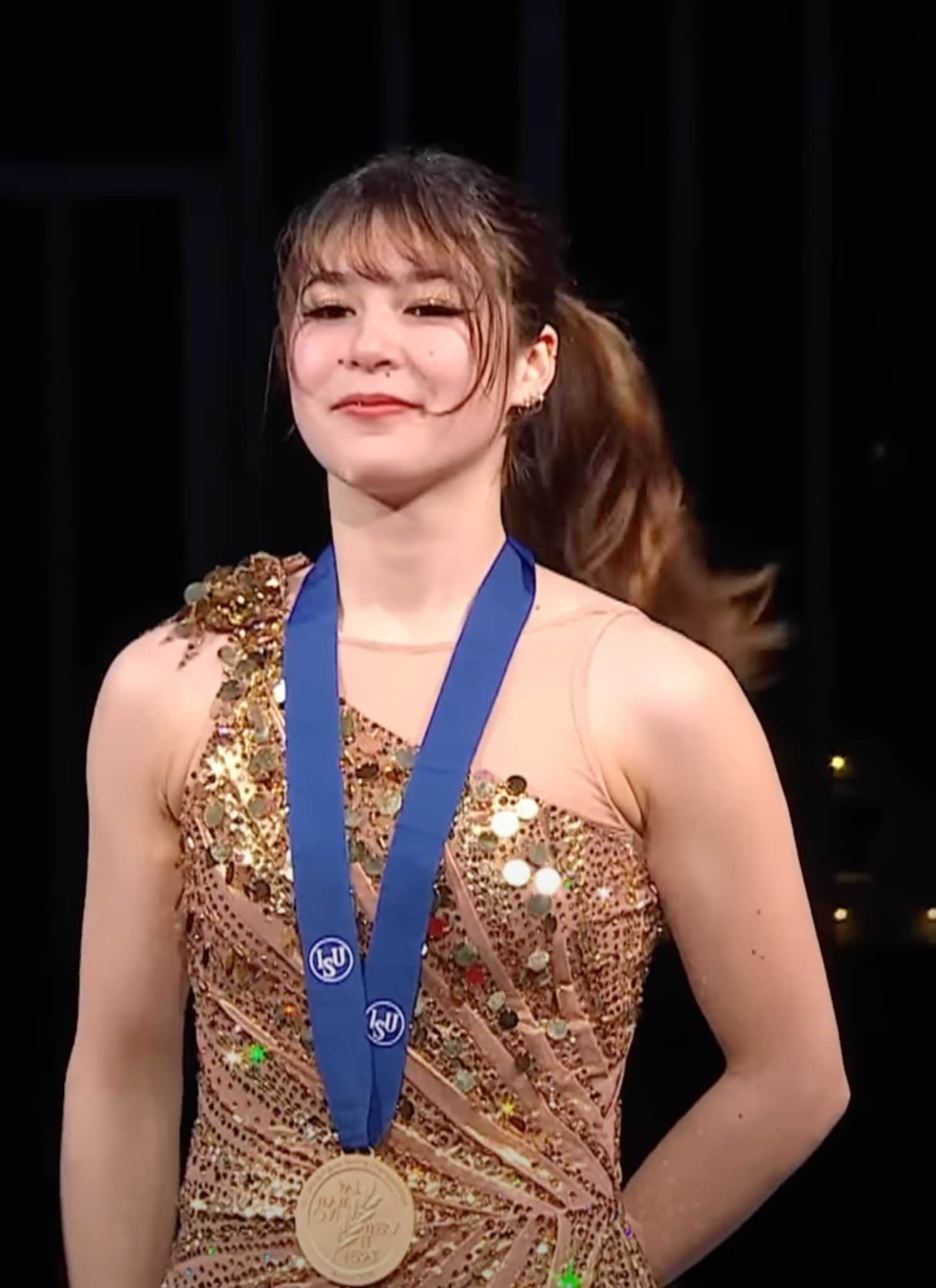 Alysa Liu in gold dress with gold medal.