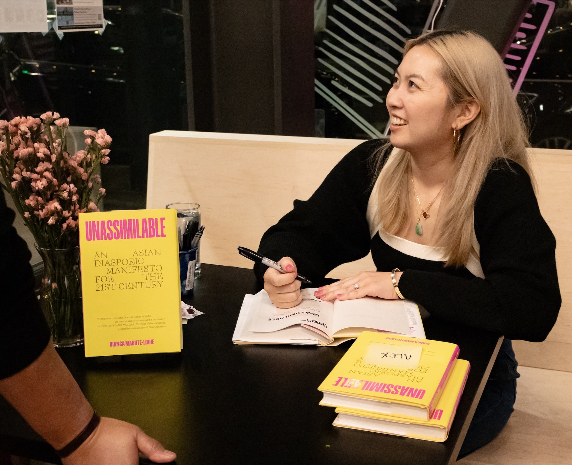 Bianca Mabute-Louie signing a copy of her book.