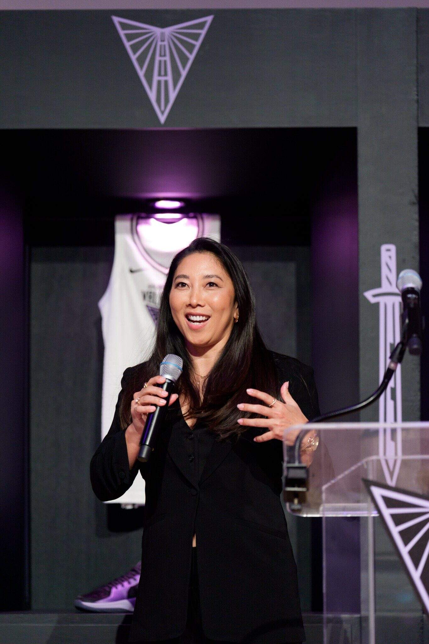 Natalie Nakase speaking at a podium.