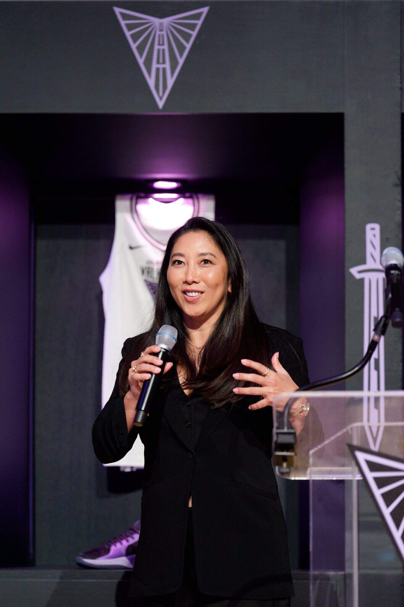Natalie Nakase speaking into a microphone.