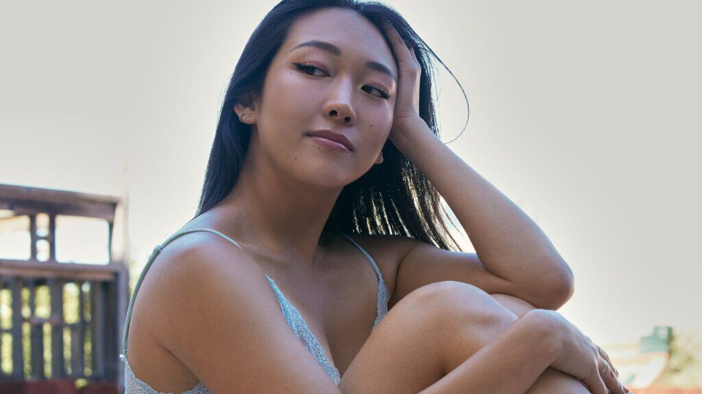 Anna Lee sitting in lingerie.