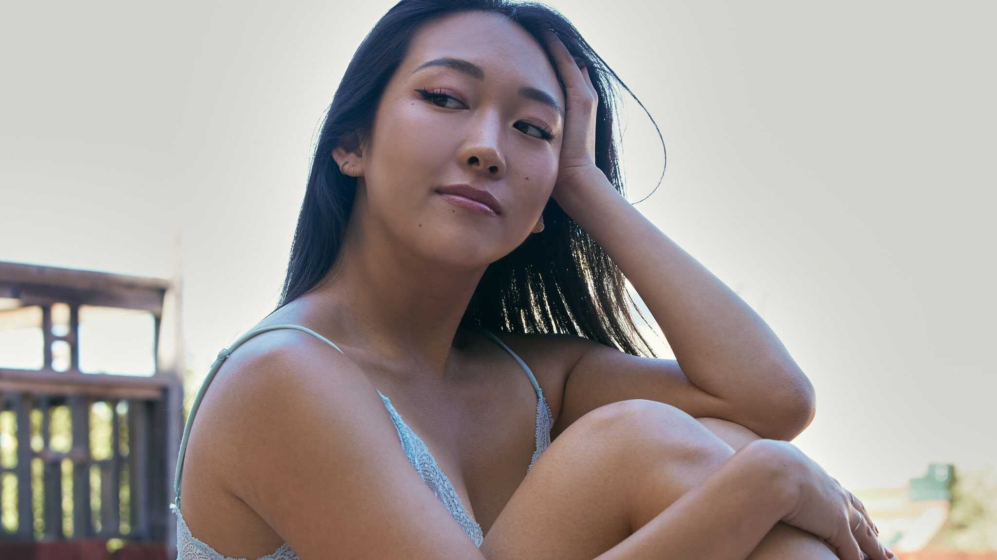 Anna Lee sitting in lingerie.