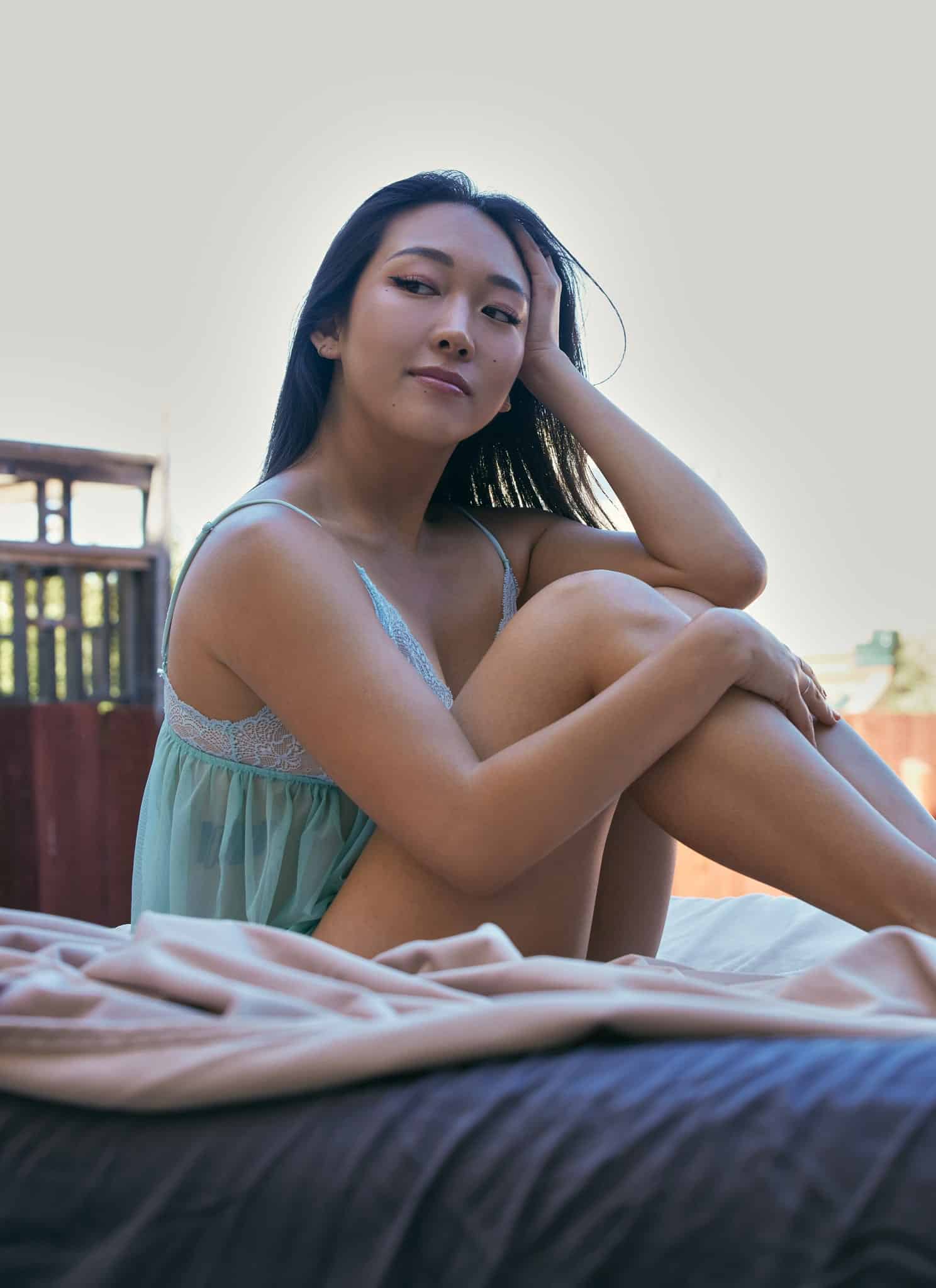 Anna Lee sitting in lingerie.