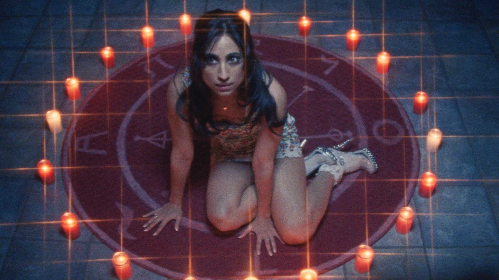 Still from FToys; a woman sits in a circle of candles.