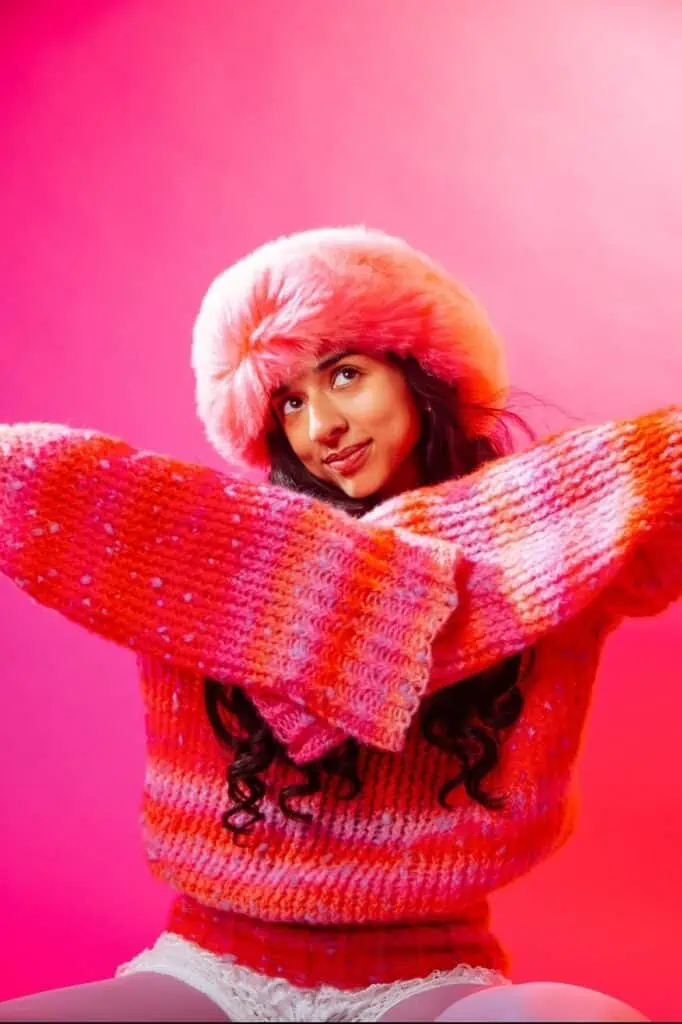 Misha Sattar posing in an orange and pink outfit.