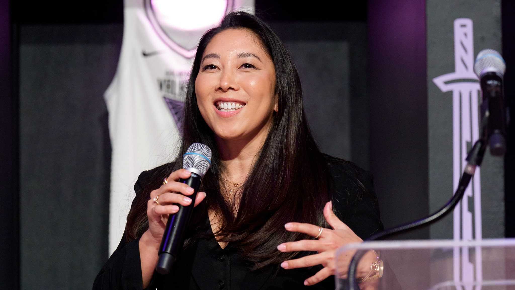 Natalie Nakase speaking into a microphone.