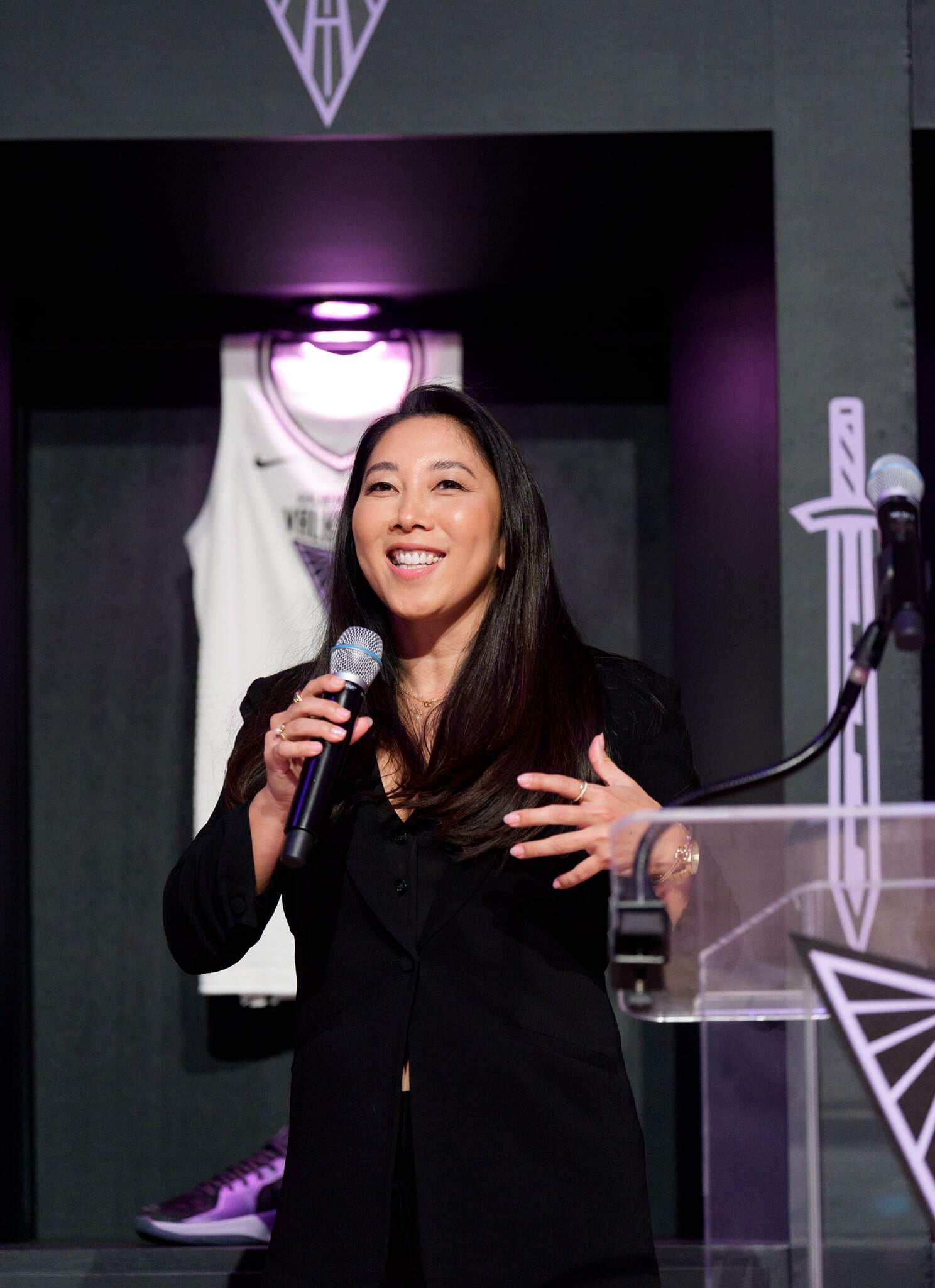 Natalie Nakase speaking into a microphone.