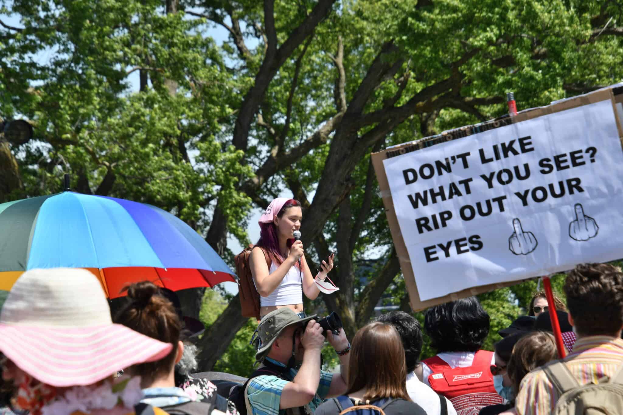 Celeste Trianon at Dyke March 2024 in Montreal speaking into a microphone surrounded by people.